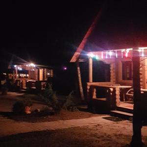 une maison avec des lumières de Noël allumées la nuit dans l'établissement Camping Oskalns, à Cēsis