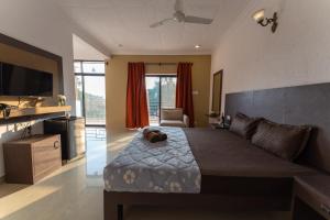 a bedroom with a large bed with a dog laying on it at Pappi Chulo Morjim in Morjim