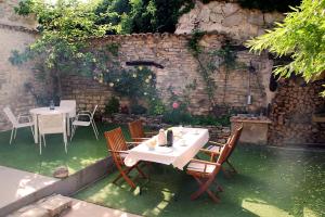 una mesa y sillas en un jardín con una pared de piedra en Cal Bové, en Sant Guim de Freixenet