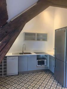 a kitchen with blue cabinets and a stainless steel refrigerator at F3 avec Jardin, Calme, Fôret, Barbizon in Chailly-en-Bière