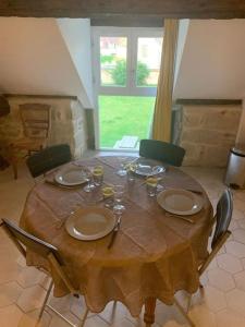 una mesa de madera con platos y copas de vino. en F3 avec Jardin, Calme, Fôret, Barbizon, en Chailly-en-Bière