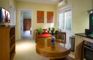 una sala de estar con un jarrón de flores sobre una mesa en Villa Topaz, en Laem Set Beach