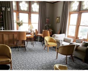 Una sala de estar con sillas, un sofá y una mesa. en The Regency - Historic residences by the sea, en Ilfracombe