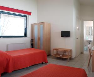 a bedroom with a bed and a window and a television at Bambù Affittacamere & Residence in Teramo