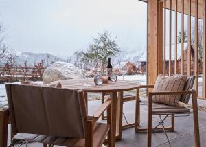 una mesa y sillas en un porche con una botella de vino en HILL - 73 by AA Holiday Homes, en Tauplitz