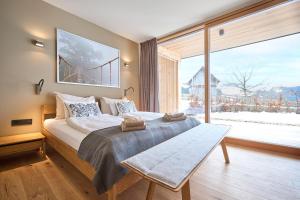 1 dormitorio con 1 cama grande y ventana grande en HILL - 73 by AA Holiday Homes, en Tauplitz