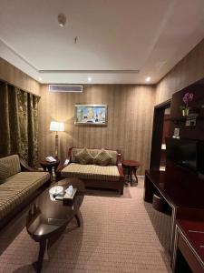 uma sala de estar com um sofá e uma mesa em EKONO by Leva Jeddah Airport Hotel em Jeddah