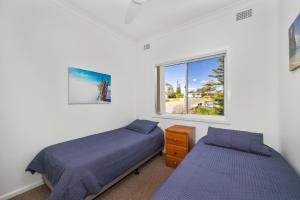 sypialnia z 2 łóżkami i oknem w obiekcie Seaside Beach House w mieście Burrill Lake