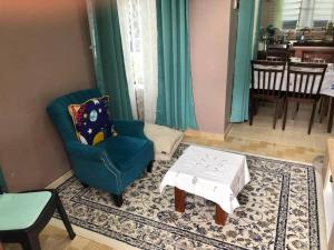 a living room with a blue chair and a coffee table at Whole house - 2 bedrooms for family with kids and Free Wifi in Changlun