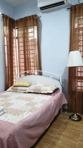 1 dormitorio con cama, lámpara y cortinas en Whole house - 2 bedrooms for family with kids and Free Wifi, en Changlun