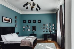 ein Schlafzimmer mit einem Bett und einer blauen Wand in der Unterkunft Sherlock Apartments in Riga