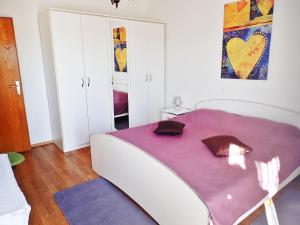 a bedroom with a large bed with a purple blanket at Apartment Putnik in Posedarje