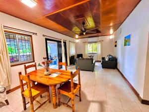 uma sala de estar com uma mesa de madeira e cadeiras em 88 Days Self Catering Holidays & Accomodation em Baie Lazare Mahé