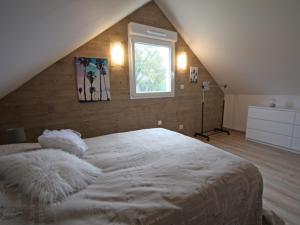 a bedroom with a large white bed with a window at Gîte Chamagne, 3 pièces, 4 personnes - FR-1-589-11 