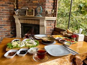 a table with plates of food and a fireplace at Medi Soho Bungalov in Rize