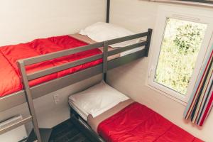 a small room with two bunk beds and a window at Terres de France - Les Hameaux de Pomette in Marminiac