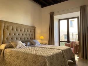 una camera da letto con un grande letto con una grande finestra di Apartamentos Casa-Palacio Santa Pola a Ronda