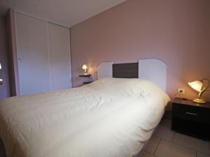 um quarto com uma grande cama branca e 2 candeeiros em Gîte Harsault, 5 pièces, 9 personnes - FR-1-589-79 em Bains-les-Bains