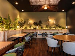 um restaurante com mesas e cadeiras e plantas na parede em Holiday Inn Bern Westside, an IHG Hotel em Berna