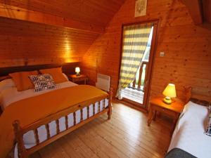 a bedroom with a bed and a window in a log cabin at Gîte Le Val-d'Ajol, 2 pièces, 2 personnes - FR-1-589-230 in Le Val-dʼAjol