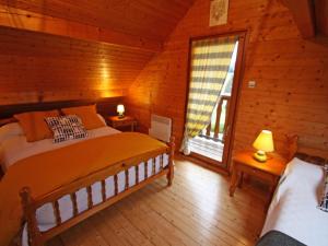 a bedroom with a bed and a window in a log cabin at Charmant Chalet Vosgien – Idéal Couple/Curistes – Calme et Nature – Proche Plombières-les-Bains - FR-1-589-230 in Le Val-dʼAjol
