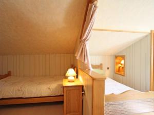 a bedroom with a bed and a lamp on a table at Gîte familial avec salle de jeux, cheminée, terrasse et proche de sites touristiques - FR-1-589-186 in Pierrefitte