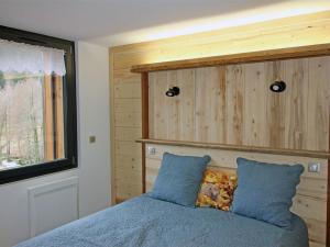a bedroom with a blue bed with a wooden headboard at Gîte 4 étoiles avec sauna et terrasses pour 14 pers. - FR-1-589-319 in Ventron