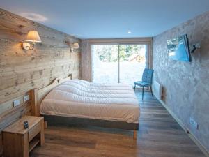 a bedroom with a bed and a chair and a window at Chalet familial spacieux avec SPA, salle de jeux, près des pistes - 14 pers, Vosges - FR-1-589-366 in Ban-sur-Meurthe-Clefcy