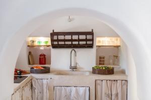 a kitchen with a sink with two baskets of vegetables at Trulli 18cinquantanove in Cisternino