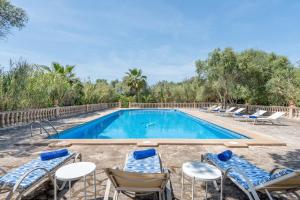 a swimming pool with chairs and a group at Finca La Encina by Mallorca House Rent in Porreres