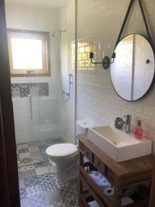 a bathroom with a toilet and a sink and a mirror at Cabana Guimarães in Rancho Queimado