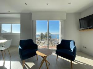 two chairs and a table in a living room with a view at Apartaments Voramar Roses in Roses