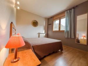 um quarto com uma cama e um candeeiro sobre uma mesa em Nuria Pedrous em Pas de la Casa