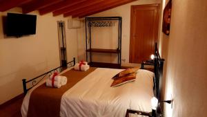 1 dormitorio con 1 cama con sábanas blancas y TV en Il Casale di Lucullo, en Lucignano