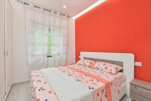 1 dormitorio con 1 cama con pared de color naranja en Casa Vacanza LaLu LeLo, en Castellabate