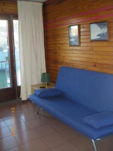 um sofá azul num quarto com uma parede de madeira em Apartamentos Varios Nievesol Avda. Encamp em Pas de la Casa