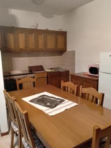 Il comprend une cuisine équipée d'une table en bois et d'un réfrigérateur. dans l'établissement La casedda di Zietta, à Aggius