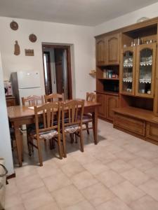 - une cuisine avec une table et des chaises en bois dans l'établissement La casedda di Zietta, à Aggius