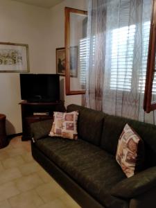- un salon avec un canapé et une télévision dans l'établissement La casedda di Zietta, à Aggius