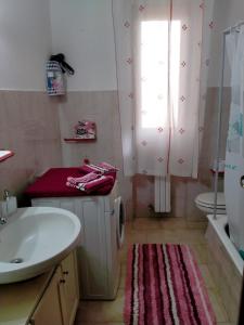 La salle de bains est pourvue d'un lavabo, de toilettes et d'une fenêtre. dans l'établissement La casedda di Zietta, à Aggius