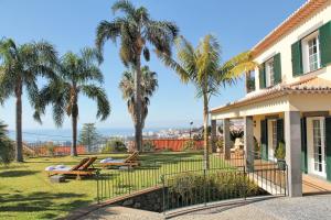 een huis met palmbomen in de tuin bij Magnificent Funchal Villa Villa Luzia 5 Bedrooms Sea City Views Pool Table in Funchal
