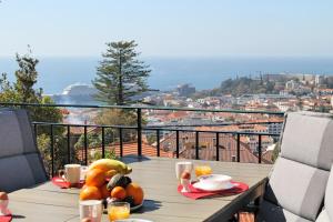 een tafel met fruit op het balkon bij Magnificent Funchal Villa Villa Luzia 5 Bedrooms Sea City Views Pool Table in Funchal