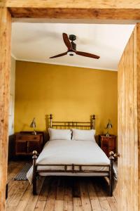 a bedroom with a bed with a ceiling fan at Bokrivier Cottages in Greyton