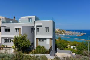 a white house with a view of the ocean at Indigo Luxury apartment in Agios Nikolaos
