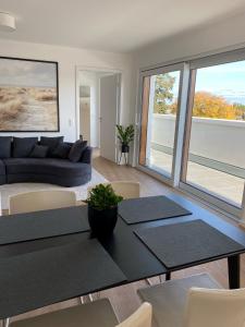 a living room with a couch and a table and chairs at Ostwall Terrassen Apartment 5.33 in Bocholt