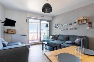 a living room with a couch and a table at À 50m de la Grande Plage, appartement pour 4 in Saint-Gilles-Croix-de-Vie