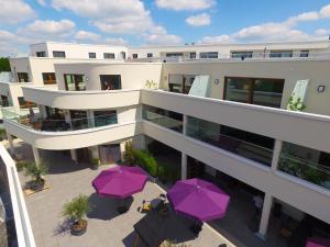 an aerial view of a building with purple umbrellas at Ostwall Terrassen Apartment 5.33 in Bocholt