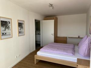 a bedroom with a bed with purple pillows on it at Ostwall Terrassen Apartment 5.33 in Bocholt