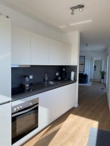 a kitchen with white cabinets and black counter tops at Ostwall Terrassen Apartment 5.33 in Bocholt