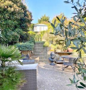 um pátio com uma mesa e cadeiras num jardim em Home away from Home - Broadstairs beautiful family seaside house with garden and parking em Kent